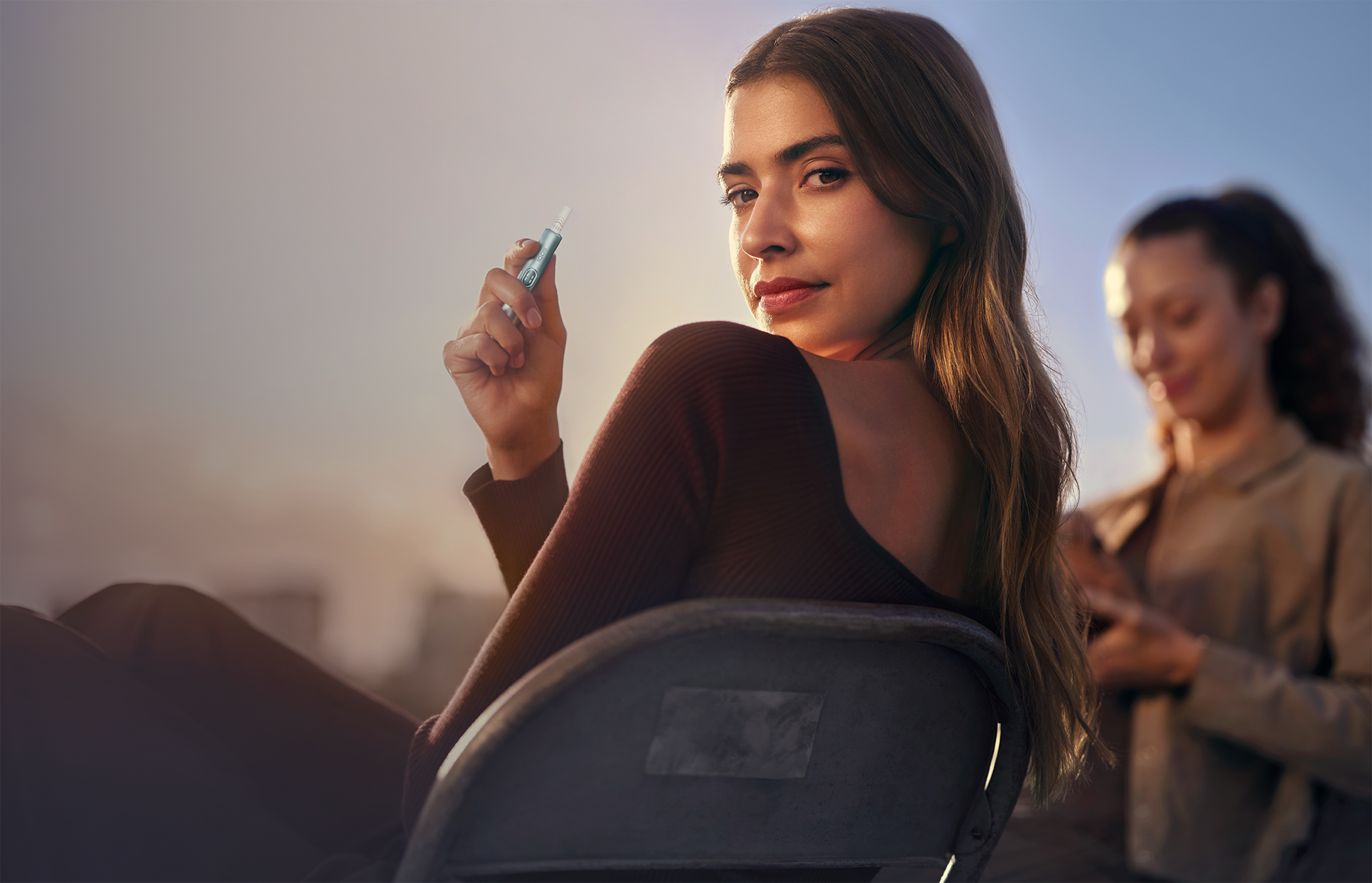 Femeie ce savurează un moment cu IQOS