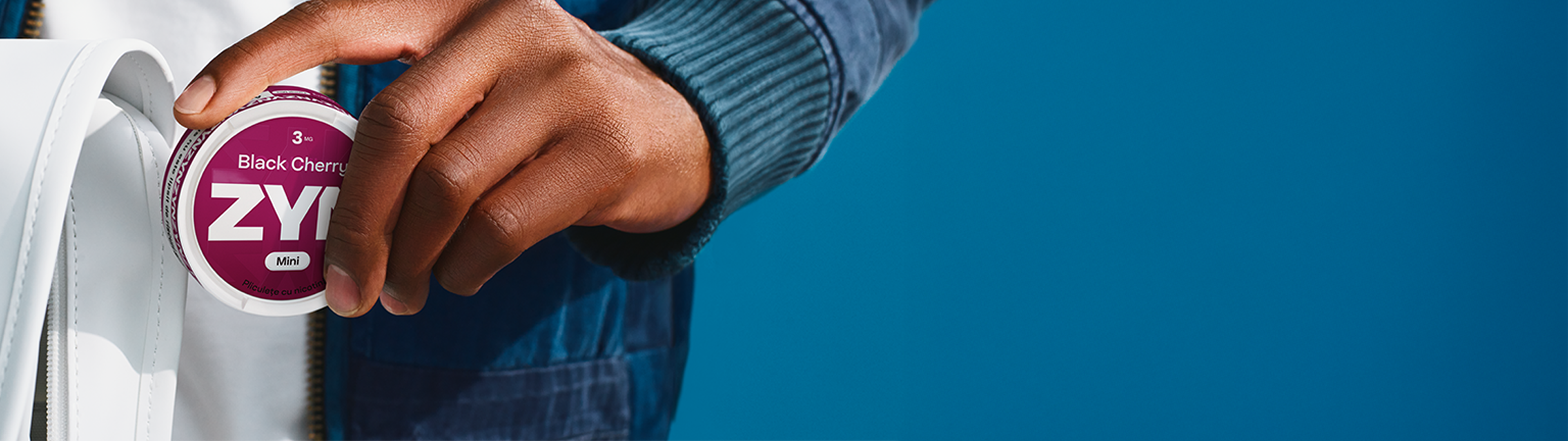 persoana care ține în mână un pachet de zyn
