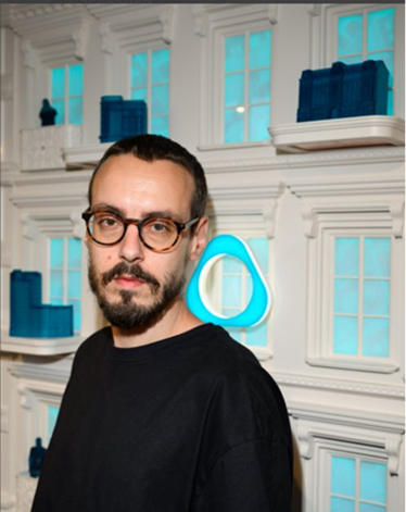 Sebastian Comanescu langa macheta unei cladiri si logo IQOS