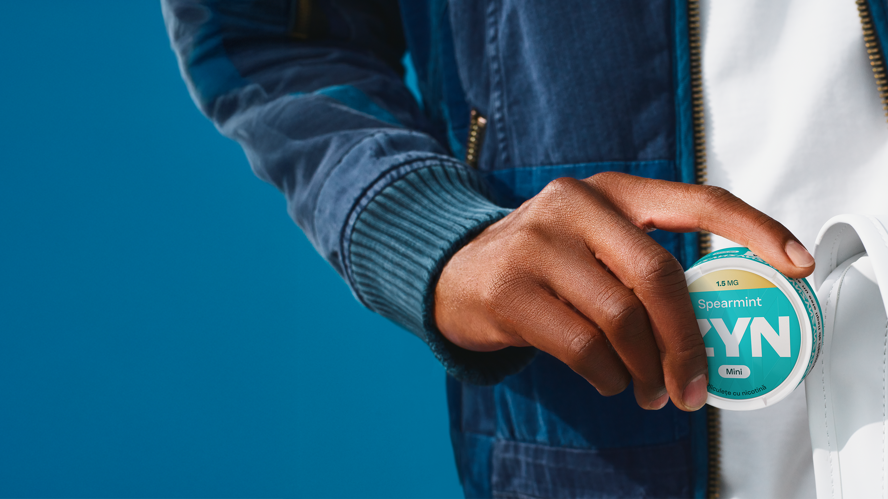 Un bărbat care ține în mână un pachet de ZYN 1.5mg Mini